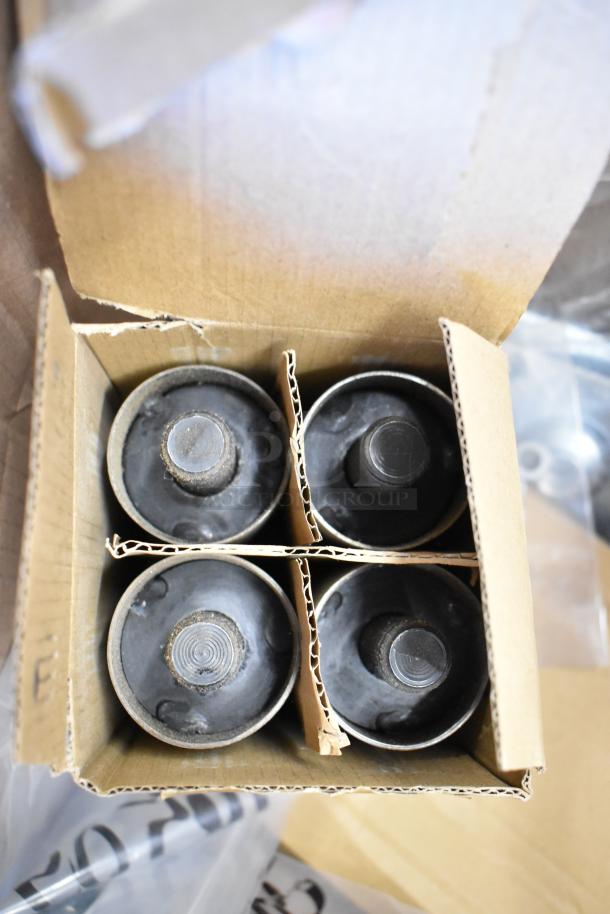 Box of metal furniture legs in carton packaging, four total, scratch and dent condition, includes screws and washers.