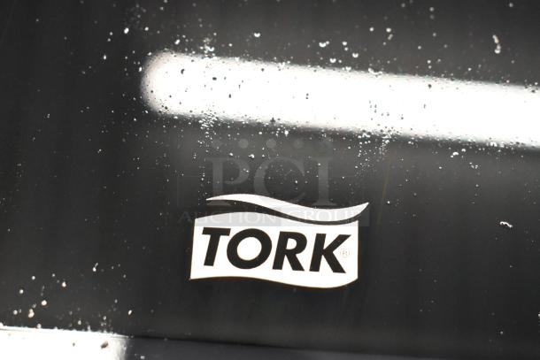 Tork PeakServe logo on a black surface with water droplets.