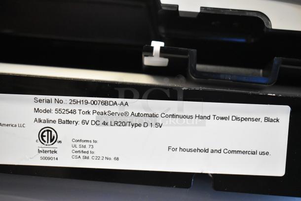 Serial number label on a Tork PeakServe 552548 Black Automatic Continuous Paper Towel Dispenser for household and commercial use.