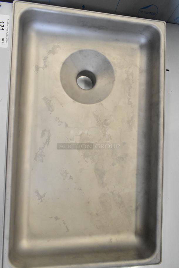 Brand new metal tray for meat grinder with visible scratches and dents, rectangular shape, center hole for attachment.
