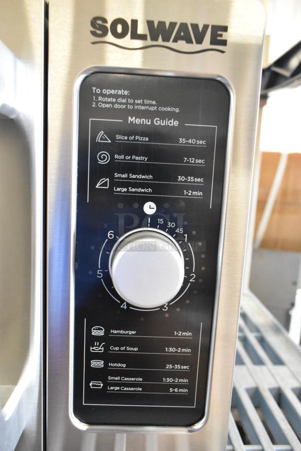 Solwave 180MW1000D stainless steel microwave with dial control, menu guide visible. Brand new, minor scratches. 120V, 1 phase.