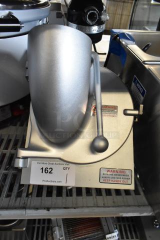 Brand new metal commercial pelican head with grating blade. Visible warning labels; minor scratches, no major dents.