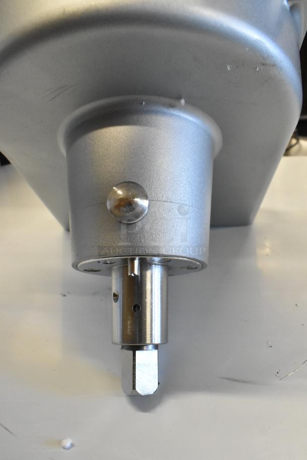 Brand new metal commercial pelican head with grating blade, slight scratches visible, in excellent condition.