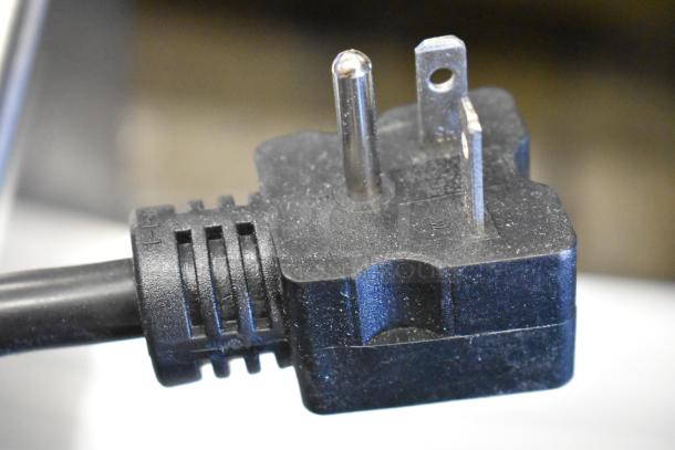 Close-up of a power plug from a ServIt 423FW200D stainless steel dual well food warmer, showing three prongs.
