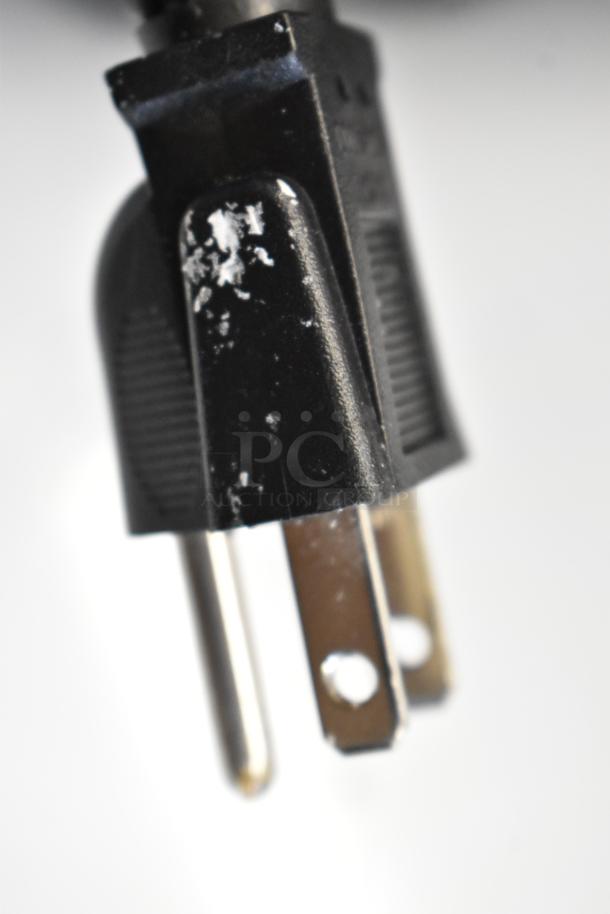 Close-up of a power plug with visible scratches on the surface, indicating slight cosmetic wear.