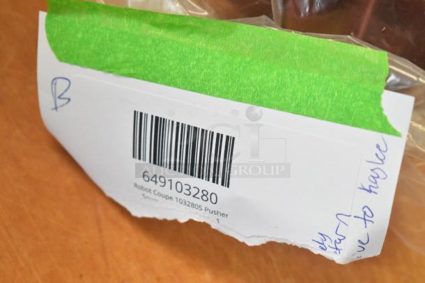 New Robot Coupe 103280S Pusher with scratch and dent imperfections, barcode and handwritten note visible, item label attached.