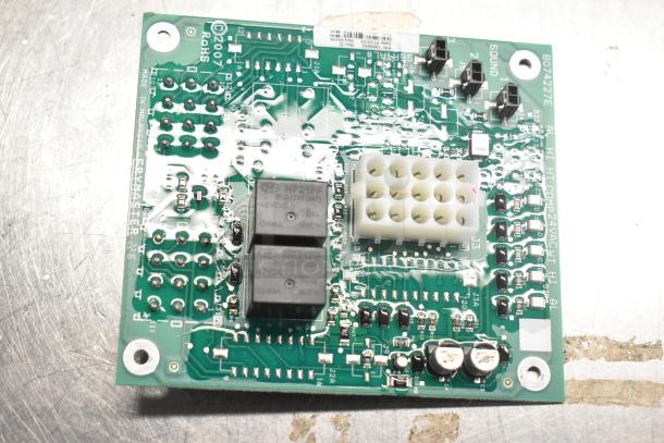 Electronic circuit board, featuring capacitors, relays, and connectors. Marked "RoHS," "Frymaster," model 8074227E.
