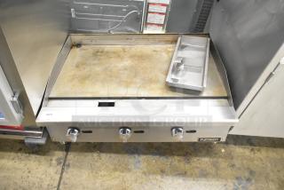 Patriot stainless steel commercial gas griddle, countertop model, well-used condition, three control knobs, branded marking visible.