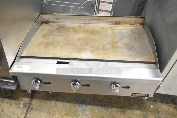 Patriot stainless steel gas-powered griddle, used, with three control knobs and slight surface wear. Model details not visible.