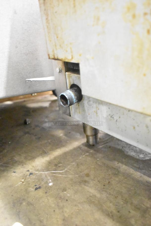 Patriot stainless steel commercial countertop gas griddle, showing the underside connection point. Visible signs of use.