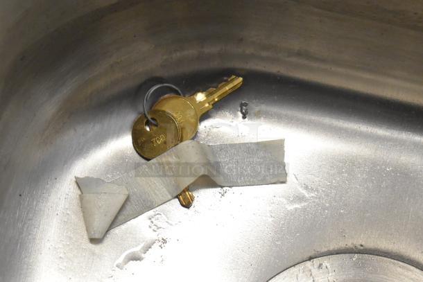 QualServ stainless steel sink with visible keys and tape inside the basin, showcasing its unused condition.