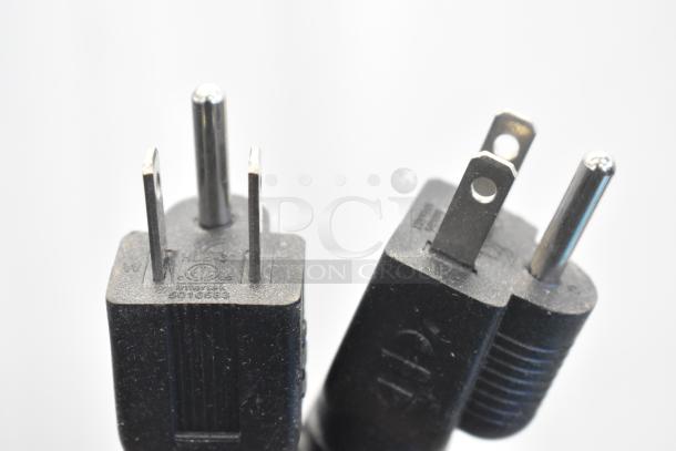 Alt Text: Close-up of two black electrical plugs with prongs, suitable for a commercial appliance use.