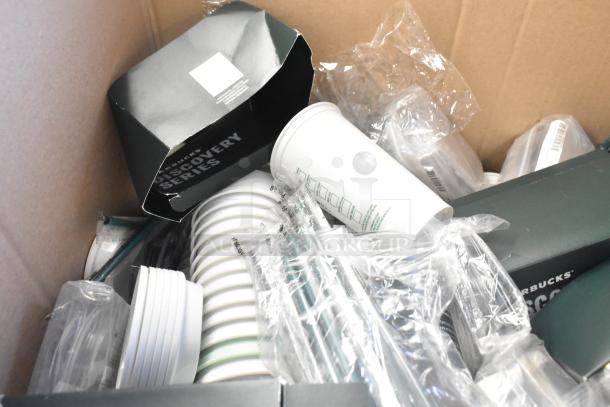 Lot of assorted Starbucks items including cups, straws, lids in a box. Some items in plastic, seen with "Discovery Series" packaging.