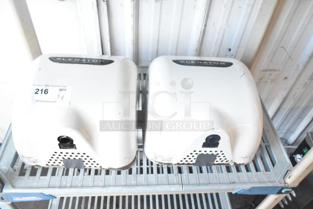 3 Xlerator XL-W white metal wall mount hand dryers, 110/120 volts, 1 phase. Each unit shows signs of use, visible branding.