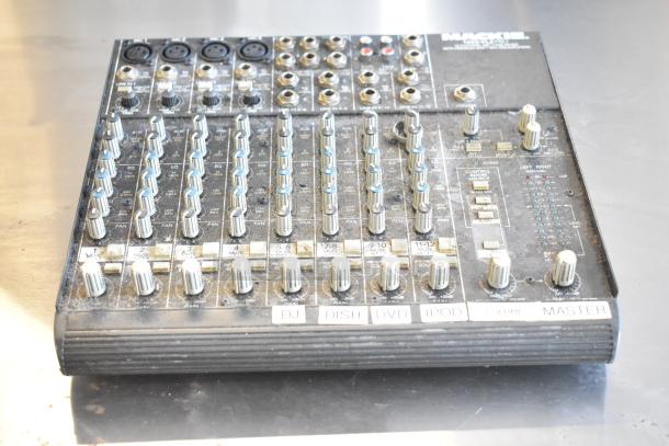 Mackie 1202-VLZ Pro 12 Channel Mic/Line Mixer, dusty surface, features multiple knobs and inputs, labels indicate usage.