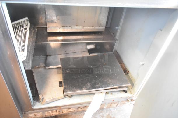 Delfield 4460N-24M-QZN stainless steel prep table, interior view, used condition, features shelving and compartment space.