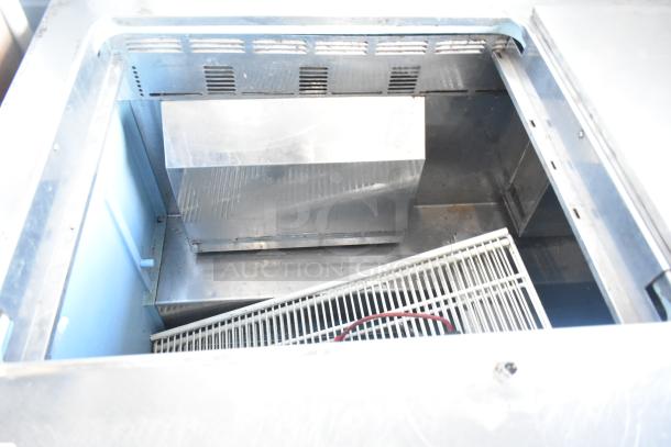 Delfield 4460N-24M-QZN stainless steel prep table, interior view showing cooling compartment and shelving. 115V, 1 phase.