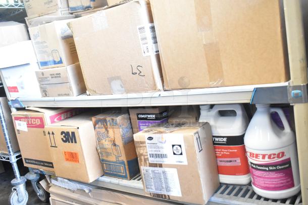 Tiered lot of cleaning products, featuring Betco Skin Cleanser, Coastwide Floor Cleaner, and Coastwide Lemon DC Plus. Boxes and bottles are shown on shelves, indicating bulk quantity.