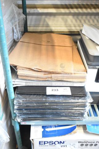 Lot of brown paper bags and Acco binders. Includes stacked bags and sealed black binders, tagged as quantity 1 lot.