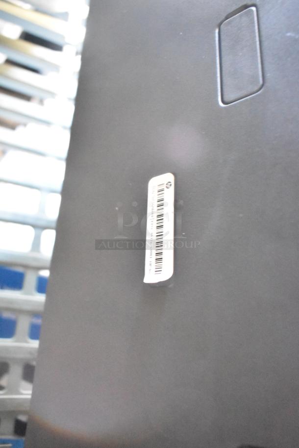 HP countertop printer scanner copier, black surface with a visible barcode label, indicating model and serial details.