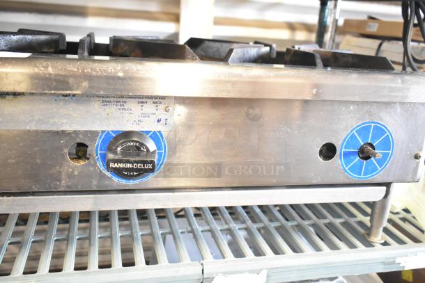Rankin-Delux stainless steel commercial 2-burner gas range, countertop model, shows moderate wear, with visible labels and settings.