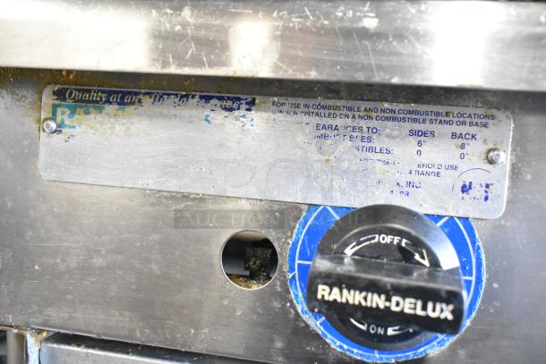 Rankin-Delux stainless steel 2 burner range, gas-powered, with visible control panel and label detailing installation instructions.