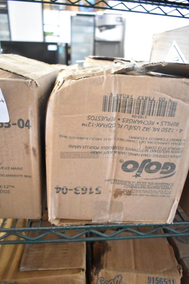 Three-tier lot of various boxes including Gojo Green Hand and Body Wash. Boxes show signs of wear. Gojo label visible.