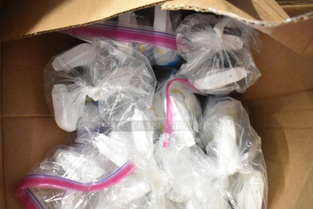 Box containing various items in plastic bags, including Clorox Disinfectant Spray and Expo White Board Care.