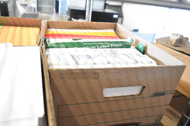 Cardboard box of assorted paper, including Hammermill Laser Print, in good condition, visible labels, various colors.