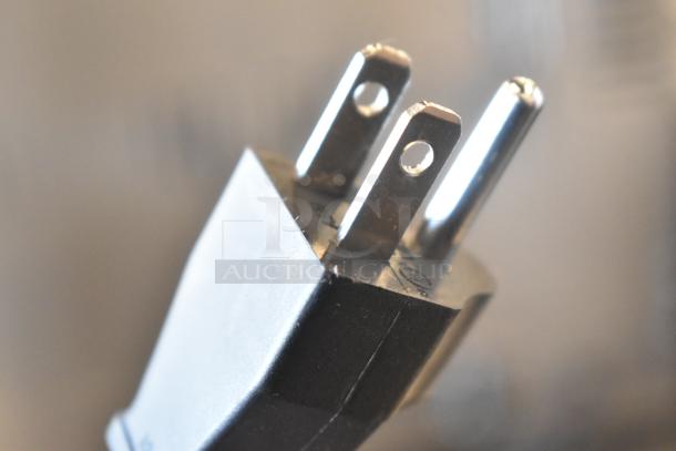 Close-up of a two-prong plug for a DeLonghi ENV150GY Nespresso VertuoPlus Single Cup Coffee Machine, 120 volts, 1 phase.