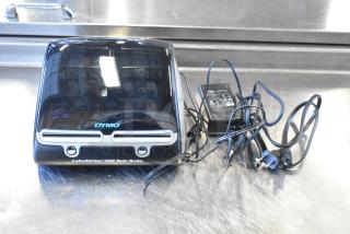 Dymo LabelWriter 450 Twin Turbo printer with power adapter and cables; sleek black design, minor wear visible.