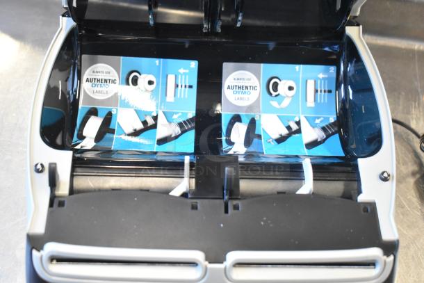 Dymo LabelWriter 450 Twin Turbo Label Printer, open with instructions for label installation, emphasizes using authentic Dymo labels.