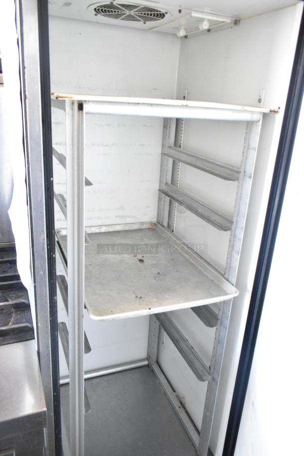 True TM-24 stainless steel commercial cooler with metal rack, on casters, 115 volts, single phase. Interior view shown.