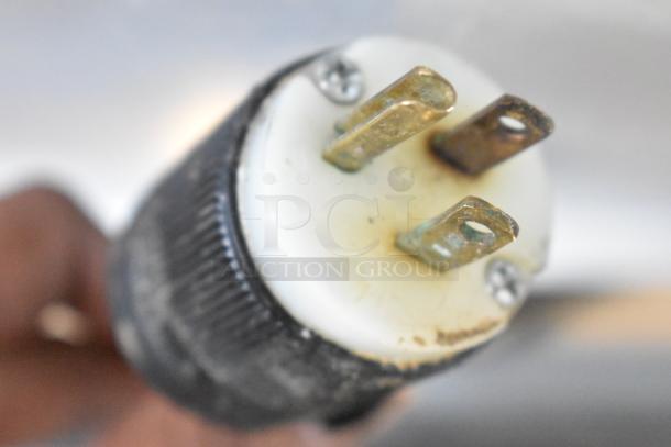 Close-up view of a three-prong plug on the 2017 Continental CPA68 stainless steel commercial prep table, 115 Volts, 1 Phase.