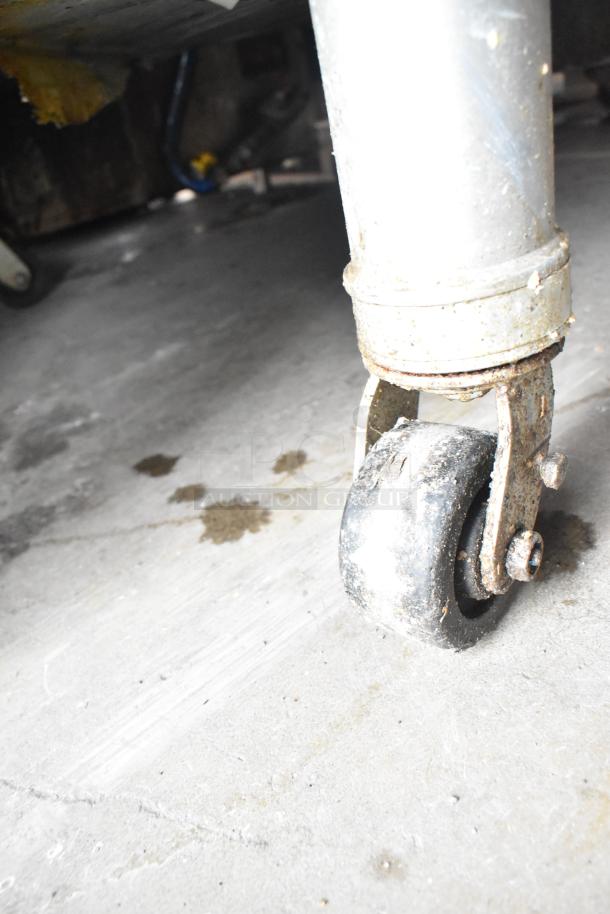 Close-up of a commercial caster wheel attached to a 2021 Middleby Marshall PS638G conveyor pizza oven, showing usage wear.