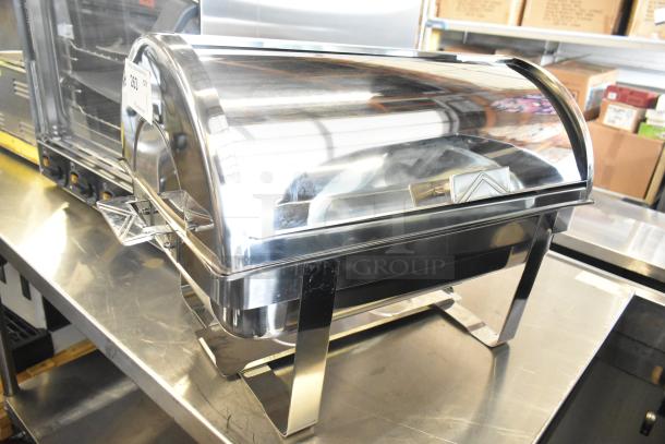 Brand new stainless steel chafing dish with minor scratches. Includes a roll-top lid and sturdy legs. Suitable for catering.