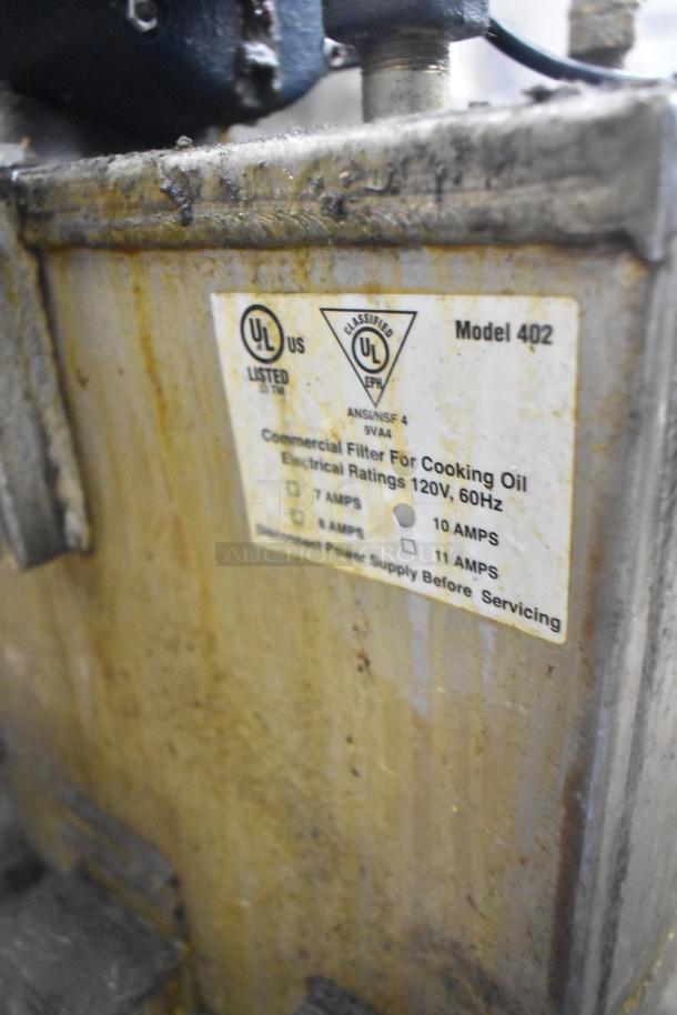 "Model 402 Metal Commercial Portable Fryer Oil Filter, 120V, UL listed. Shows use-related wear, with labels visible indicating specs."