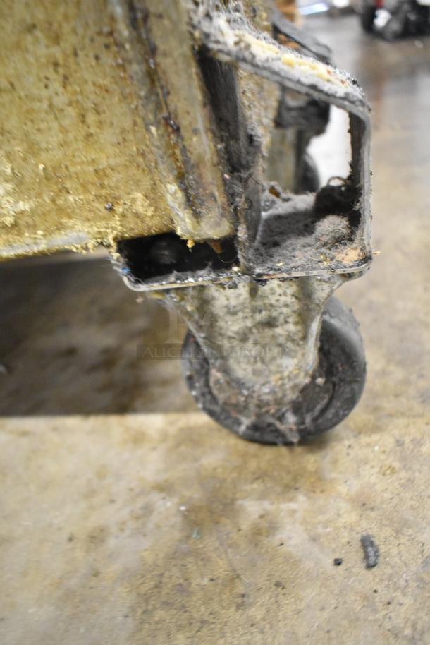 Metal commercial portable filter for fryer oil, Model 402. Features a visible caster wheel, showing wear and grease accumulation.