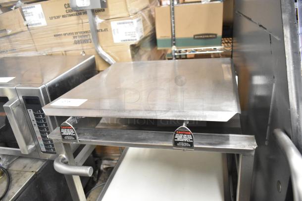 Face to Face stainless steel commercial meat slicer equipment stand in excellent condition, with caution labels visible.