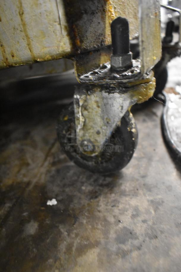 Rusty caster wheel of a 402 Metal Commercial Portable Filter for Fryer Oil, showing visible wear and grease buildup.
