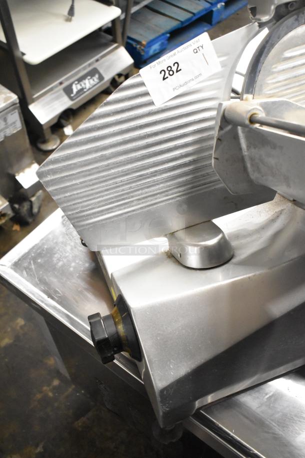 Stainless steel commercial meat slicer, model 7510, with blade sharpener. Features 120 volts, 1 phase. Auction tag visible.