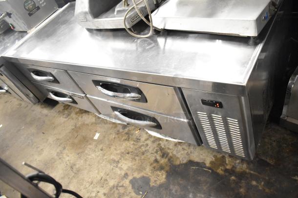 Stainless steel 4-drawer chef base on commercial casters, 115 volts, 1 phase, used condition. Silver finish, vented side panel.