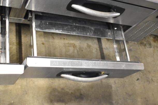 Stainless steel commercial 4 drawer chef base on casters, showing open drawer. Operates at 115 volts, 1 phase. Slight wear visible.