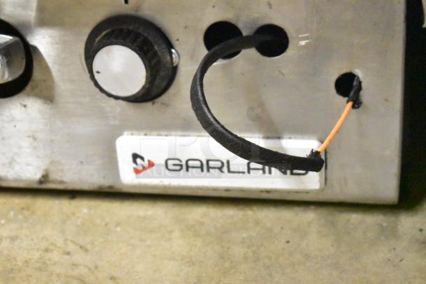 Garland stainless steel gas griddle, commercial countertop model with ridged design, control knob, and visible branding label.