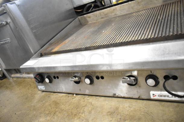 Garland stainless steel gas-powered ridged griddle, commercial countertop model, good condition, visible control knobs.