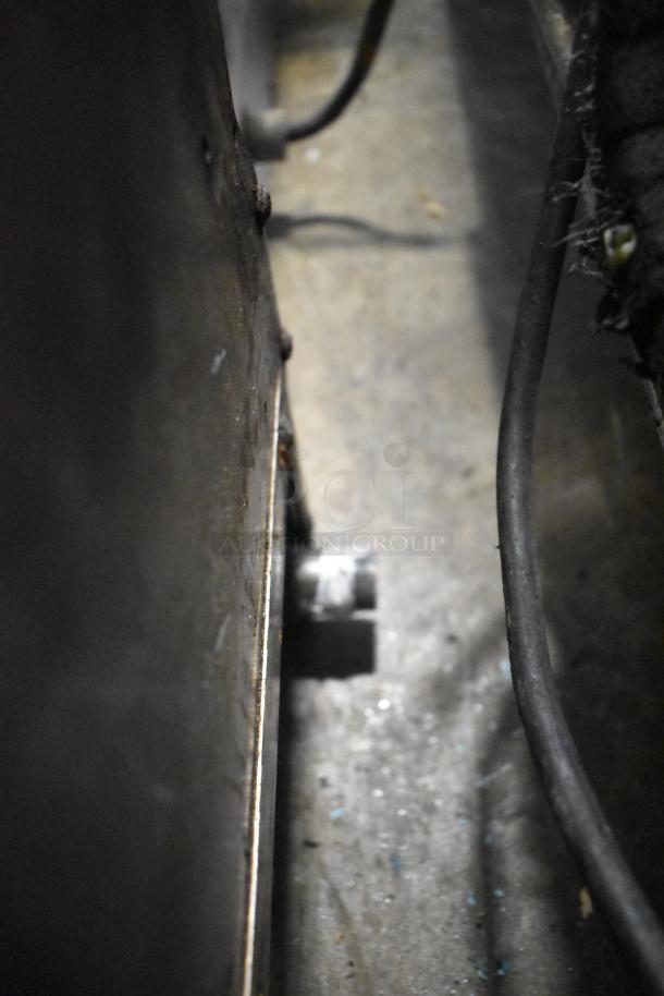 Garland stainless steel commercial countertop gas griddle, ridged surface, shows moderate wear, key for restaurant use.