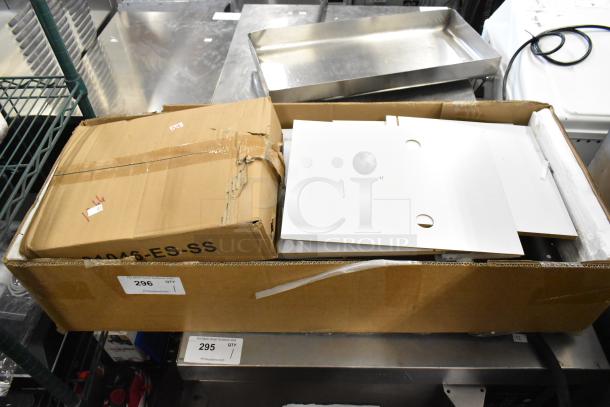 Cardboard box containing cuttable fake toy food, partially open, tagged "296 QTY 1" for auction. Box shows wear.