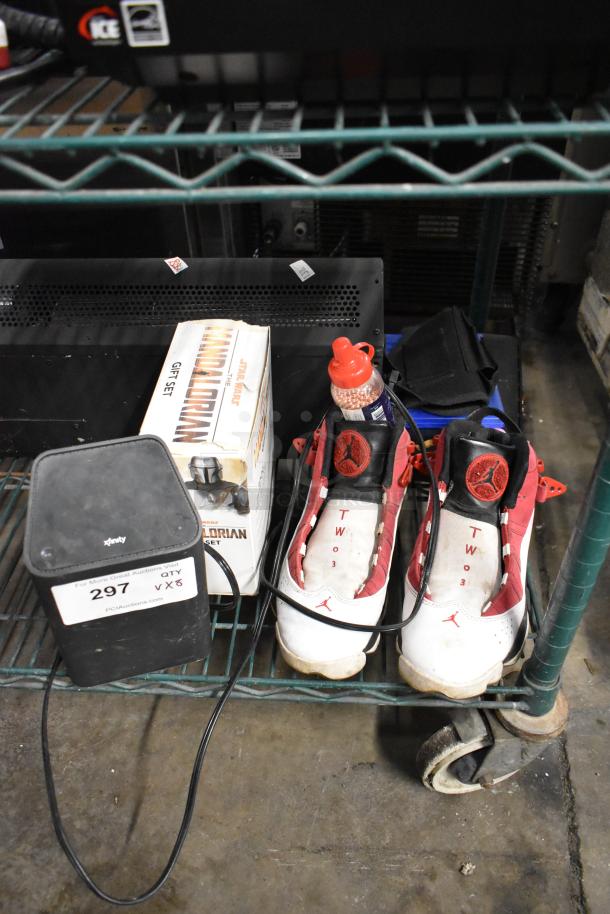 8-item auction lot: Xfinity router, Star Wars Mandalorian mug, size 8 Jordan sneakers, BB gun BBs, Batman DVD, XG2v2-P box.