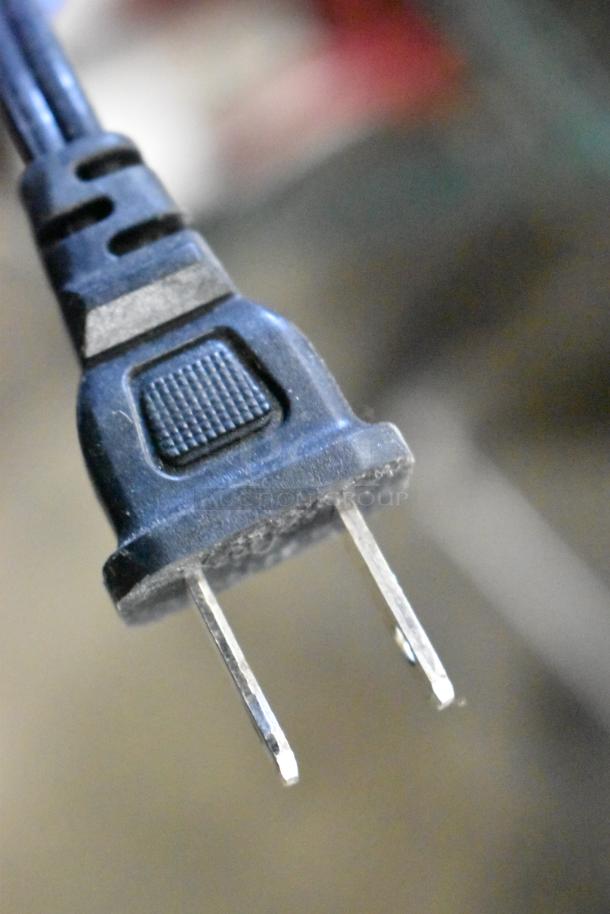 Close-up of a black power plug, likely part of the Xfinity Router in the auction lot. Visible in used condition.