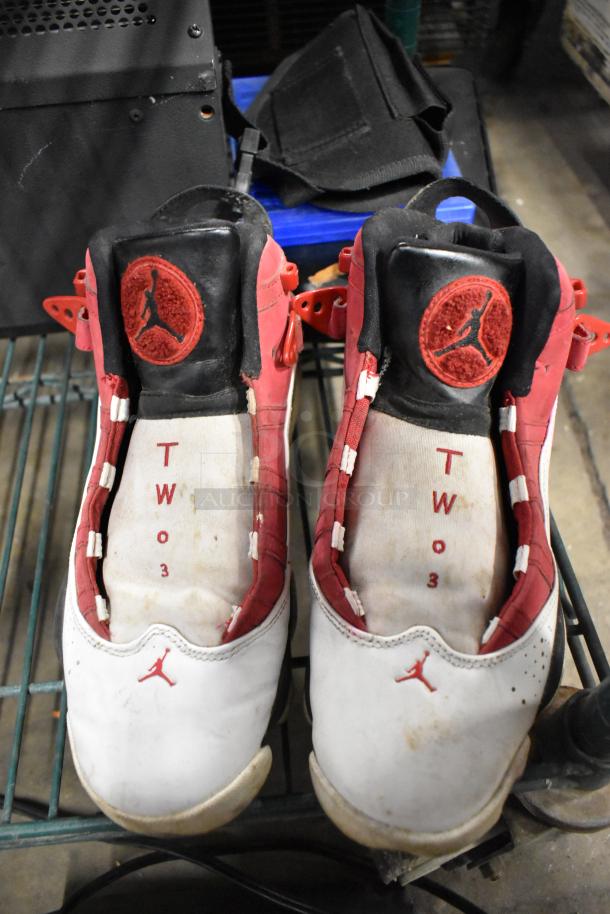 Pair of size 8 Jordan sneakers, white and red, with signs of wear. Visible Jumpman logo on tongue and sides.